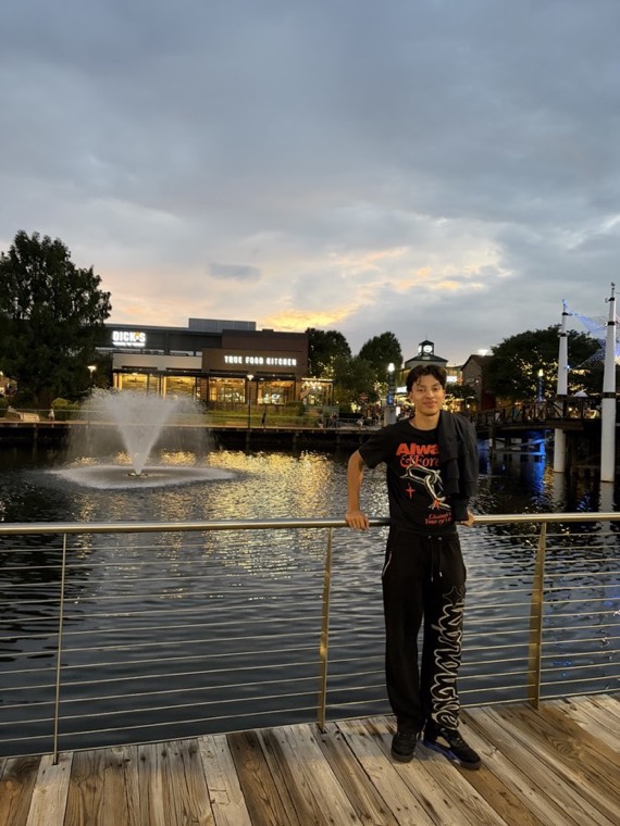 Standing by a fountain at a waterfront at dusk